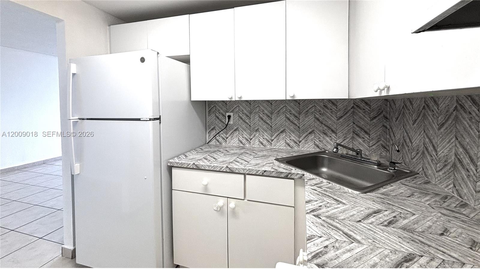 666 West 81st Street, Unit 304 Hialeah, FL 33014 - Photo 20 of 21 a kitchen with a refrigerator and a sink