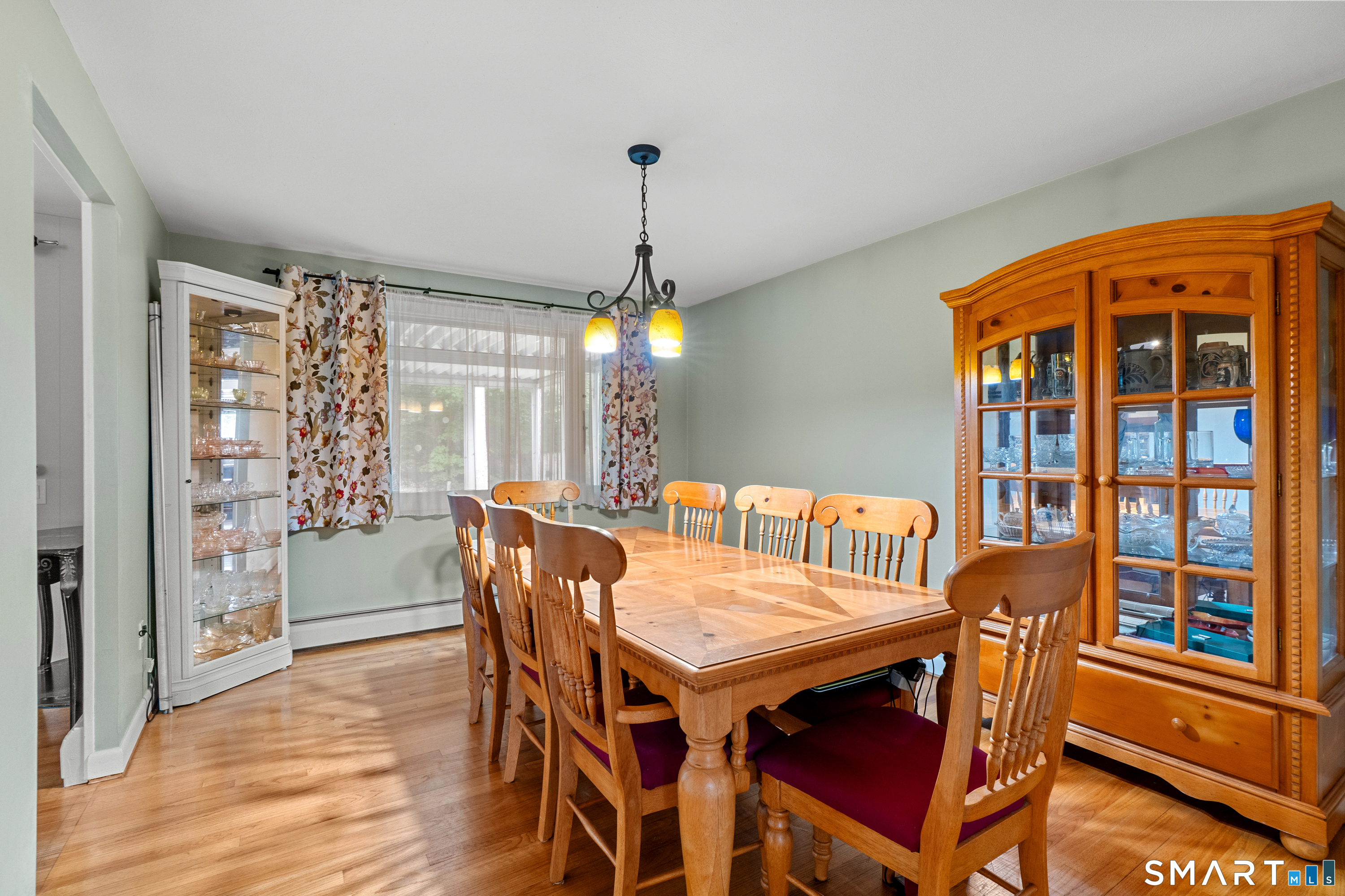 107 Round Hill Road Wethersfield, CT 06109 - Photo 17 of 40 a dining room with furniture a chandelier and wooden floor
