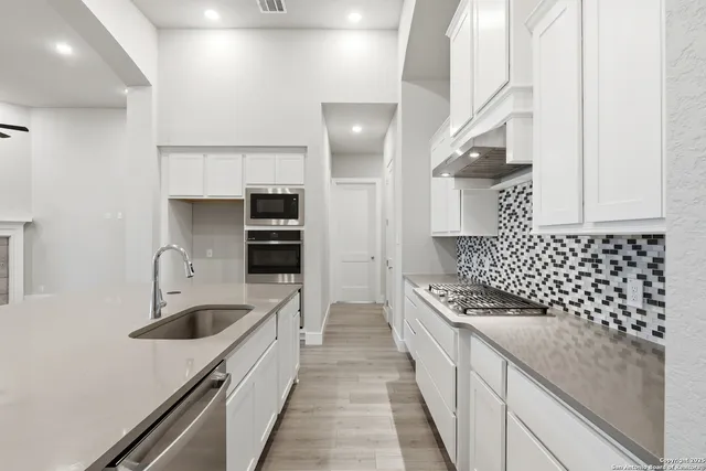 a kitchen with granite countertop a sink and a stove top oven
