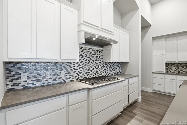 a kitchen with granite countertop white cabinets and white appliances