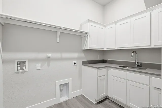 a kitchen with stainless steel appliances granite countertop a sink and cabinets with wooden floor