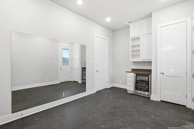 an empty room with a fireplace and natural light