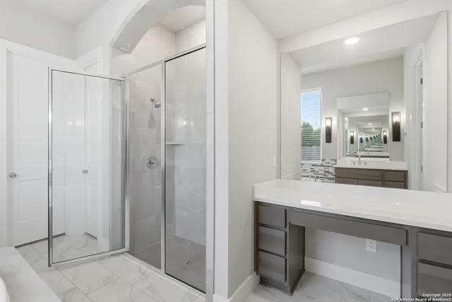 a bathroom with a sink shower and a mirror