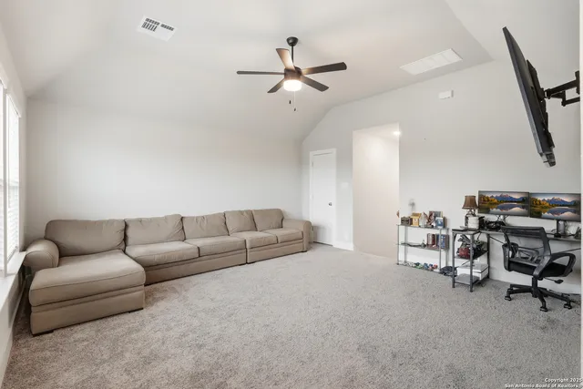a living room with furniture and a ceiling fan