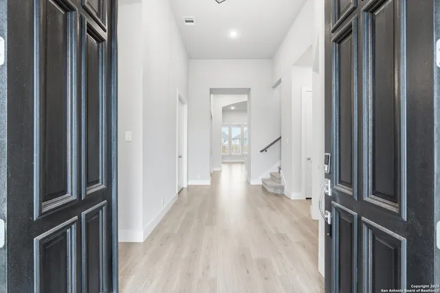 a view of a hallway with wooden floor and staircase