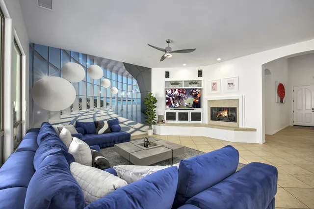 a living room with furniture fireplace and a large window