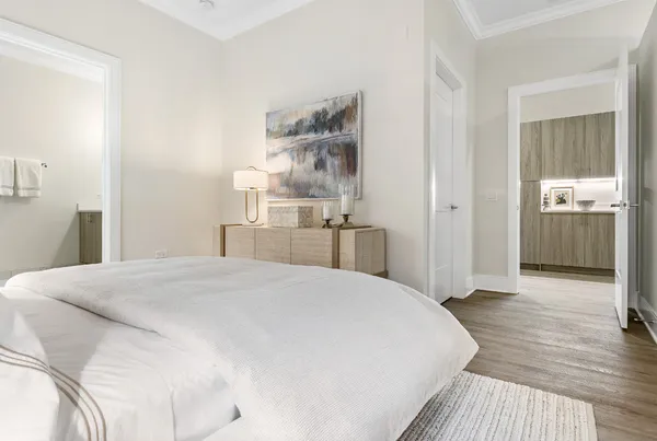 a spacious bedroom with a bed and wooden floor