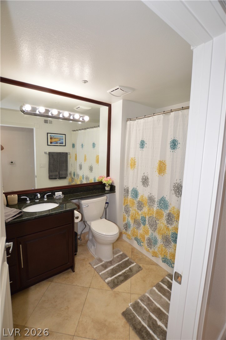 260 East Flamingo Road, Unit 332 Las Vegas, NV 89169 - Photo 15 of 36 This bright bathroom features a vanity, toilet, and a tiled shower area.