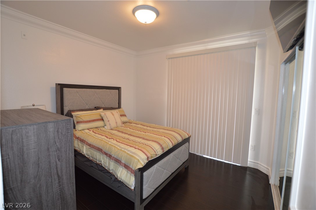 260 East Flamingo Road, Unit 332 Las Vegas, NV 89169 - Photo 16 of 36 This cozy bedroom features rich dark wood flooring and crown molding, creating a polished look.