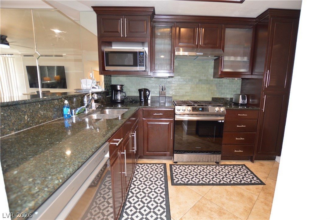 260 East Flamingo Road, Unit 332 Las Vegas, NV 89169 - Photo 4 of 36 This kitchen features rich cabinetry, granite countertops, and modern appliances for culinary pursuits.