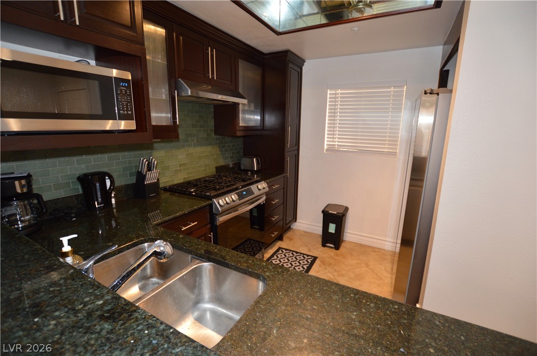 260 East Flamingo Road, Unit 332 Las Vegas, NV 89169 - Photo 6 of 36 This modern kitchen features rich cabinetry, sleek appliances, and elegant granite counters.