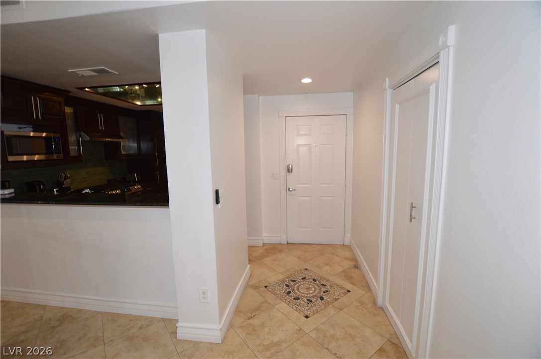 260 East Flamingo Road, Unit 332 Las Vegas, NV 89169 - Photo 8 of 36 This bright hallway connects to a contemporary kitchen, featuring a striking tiled floor design.