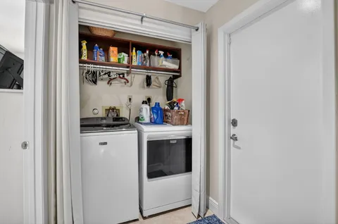 a large white kitchen with a sink and dishwasher a stove with wooden floor
