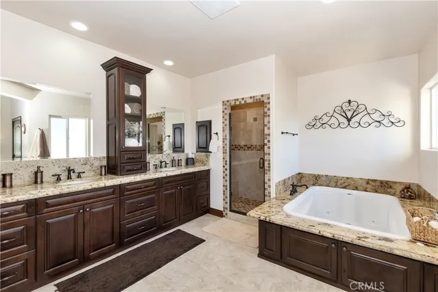 a spacious bathroom with a granite countertop tub sink and mirror