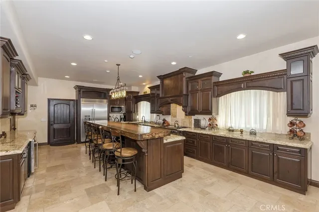 a kitchen with stainless steel appliances kitchen island granite countertop a sink and cabinets