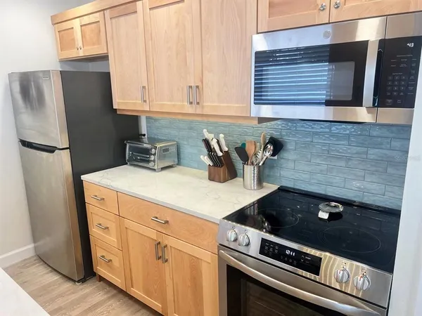a kitchen with stainless steel appliances a stove a refrigerator and cabinets