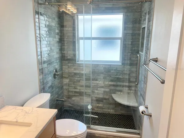 a bathroom with a toilet and a shower