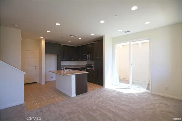 a kitchen with stainless steel appliances granite countertop a refrigerator and a stove top oven