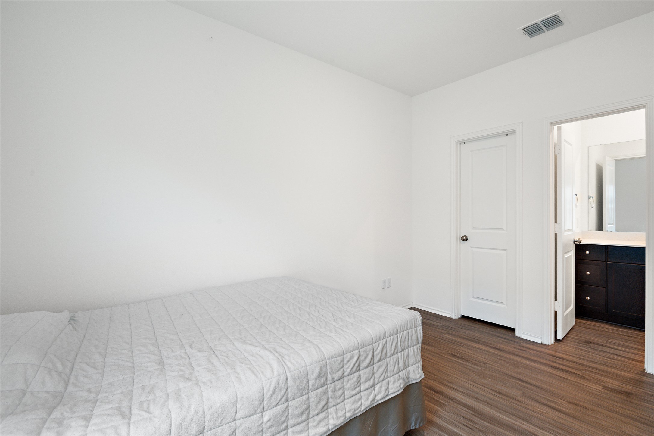 13803 Tordillo Drive Elgin, TX 78621 - Photo 19 of 39 Bedroom featuring dark wood-style floors and ensuite bath