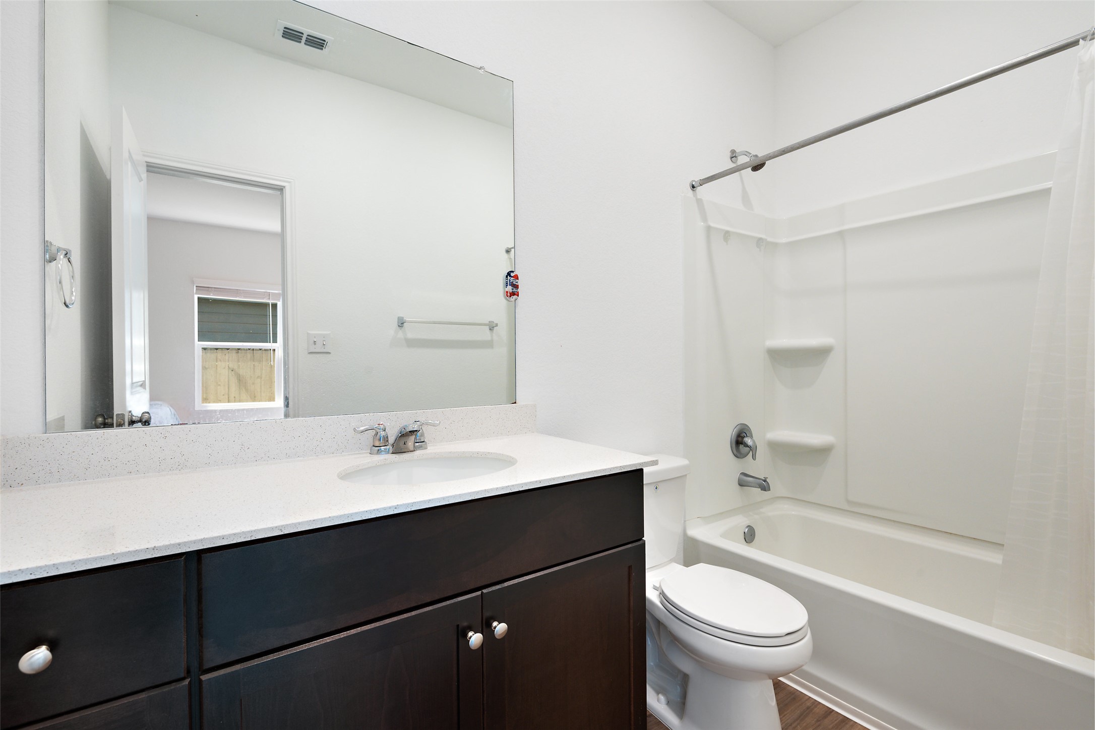 13803 Tordillo Drive Elgin, TX 78621 - Photo 20 of 39 Full bath featuring shower / bathtub combination with curtain, vanity, and dark wood-style floors