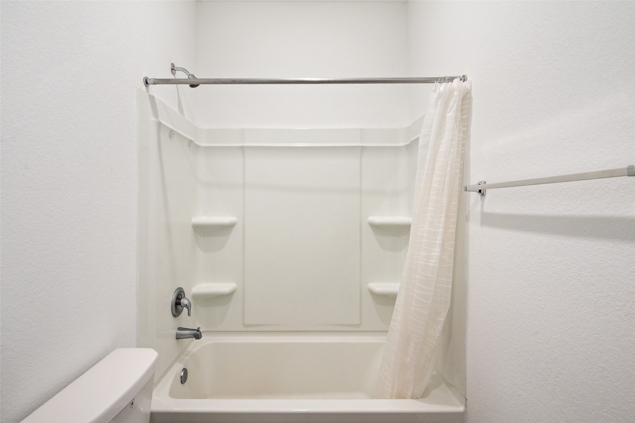 13803 Tordillo Drive Elgin, TX 78621 - Photo 21 of 39 Full bathroom featuring shower / bathtub combination with curtain and a textured wall