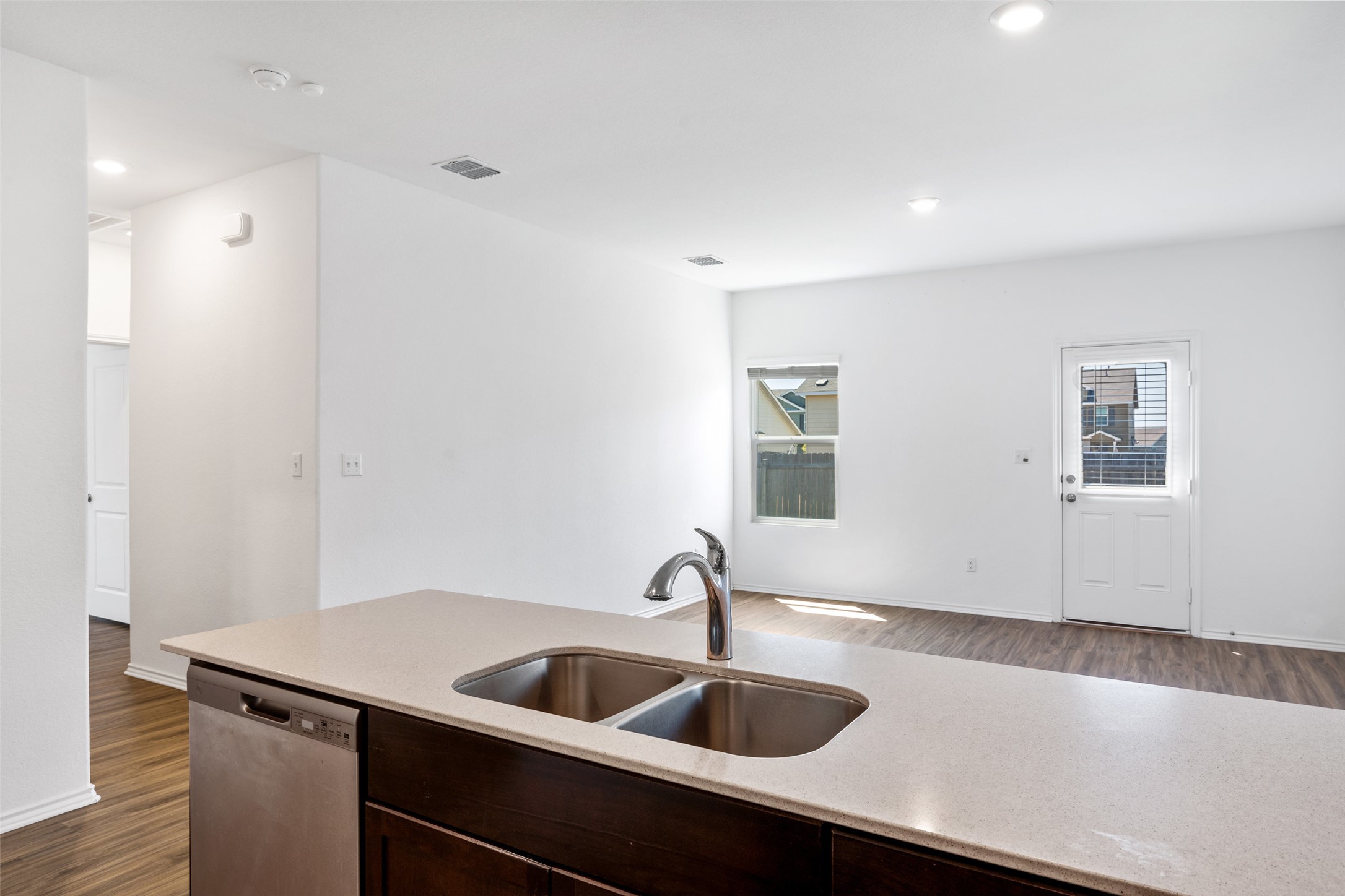 13803 Tordillo Drive Elgin, TX 78621 - Photo 6 of 39 Kitchen featuring dark wood-style floors, dark brown cabinets, dishwasher, recessed lighting, and light stone counters
