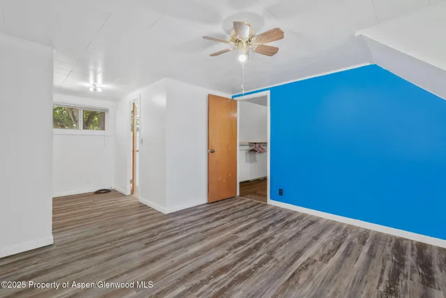 a view of empty room with wooden floor