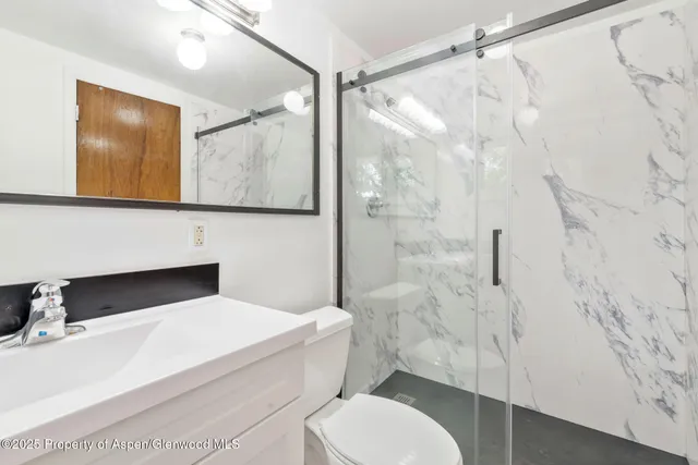 a bathroom with a toilet sink and shower