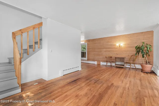 a view of a big room with wooden floor and windows