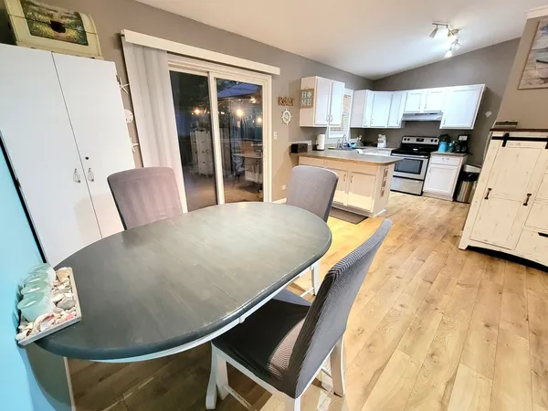 a living room with stainless steel appliances furniture a couch and a view of kitchen