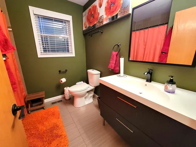 a bathroom with a sink mirror and toilet