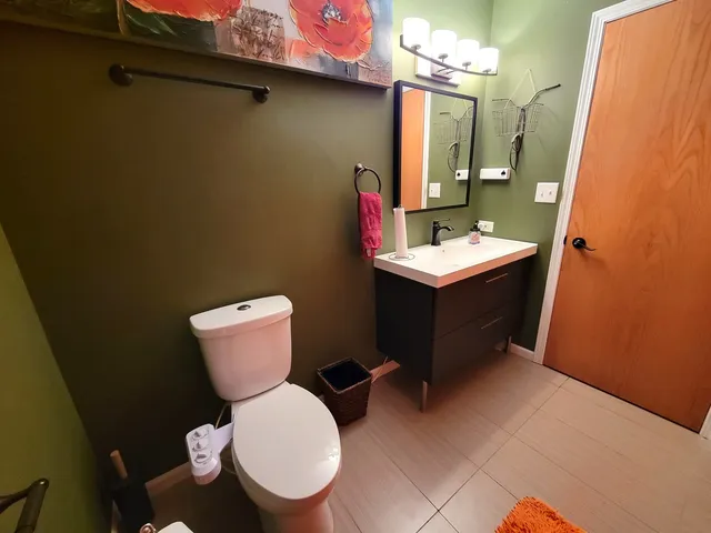 a bathroom with a toilet sink and mirror