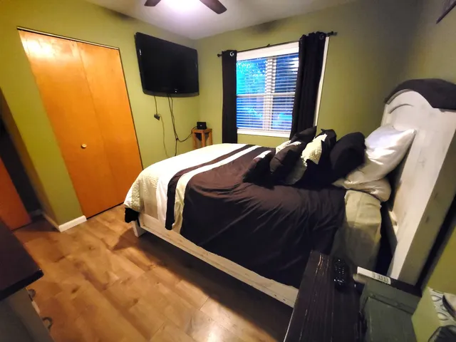 a bedroom with a bed tv and a window