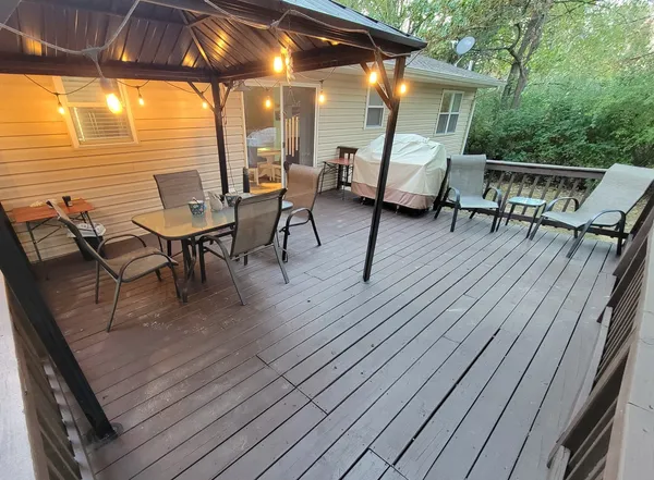 a view of deck with table and chairs under an umbrella with wooden floor