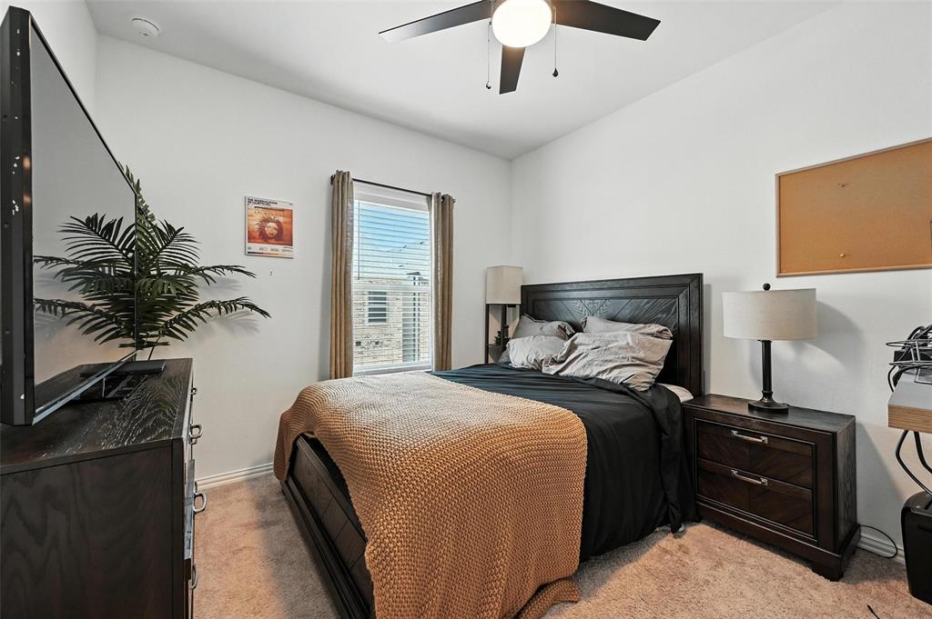 7513 Laburnam Road Dallas, TX 75228 - Photo 12 of 23 a bedroom with a bed and a potted plant on the dresser