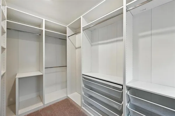 a view of walk in closet with empty racks