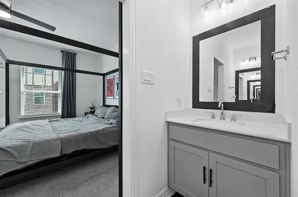 a bedroom with a bed and a large mirror next to a window