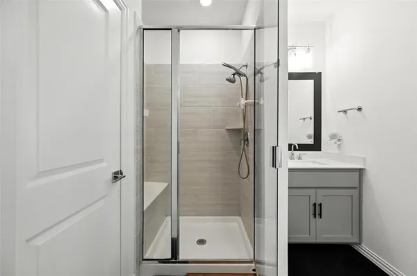 a bathroom with a shower sink and mirror