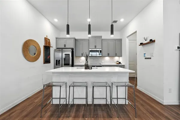 a kitchen with stainless steel appliances granite countertop a kitchen island a stove and a wooden floors