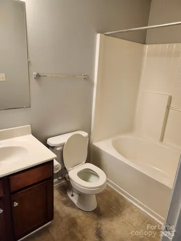 a white toilet and tub sitting next to a bathroom sink