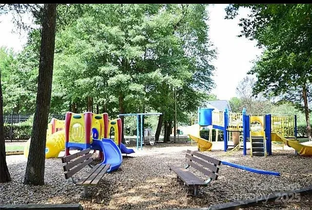 a view of a park with furniture and wooden fence