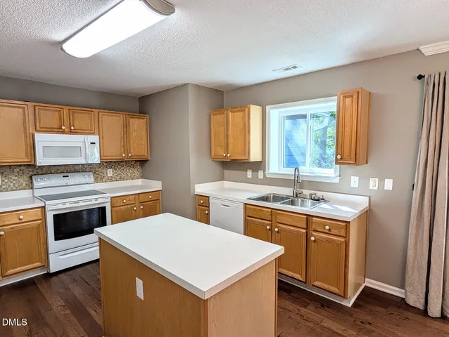 a kitchen with a stove a sink and a refrigerator