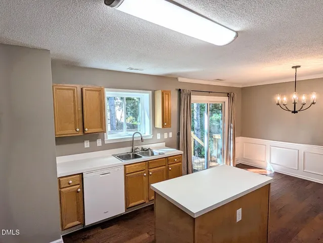a kitchen that has a sink a stove a dining table and chairs