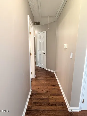 a view of a hallway with wooden floor and staircase