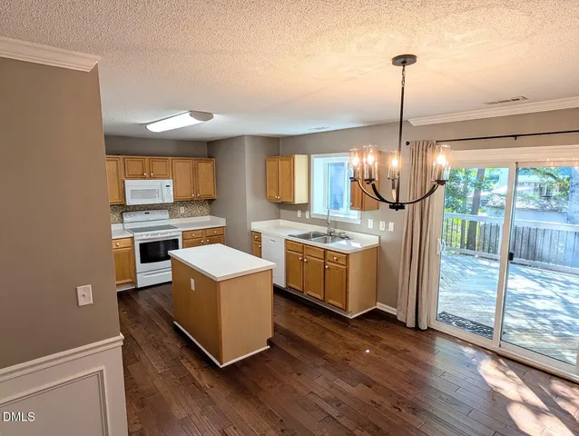 a kitchen with stove a refrigerator and wooden floor