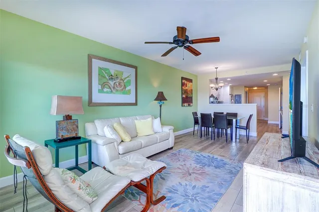 a living room with furniture a flat screen tv and a dining table