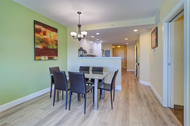 a view of a dining room with furniture a chandelier and wooden floor