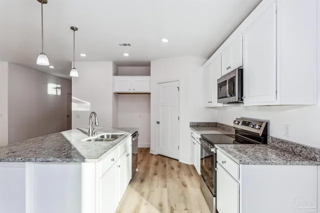 a kitchen with a sink a stove a microwave and refrigerator