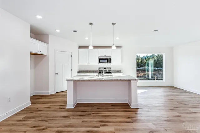 a view of kitchen with granite countertop stainless steel appliances stove a sink and dishwasher