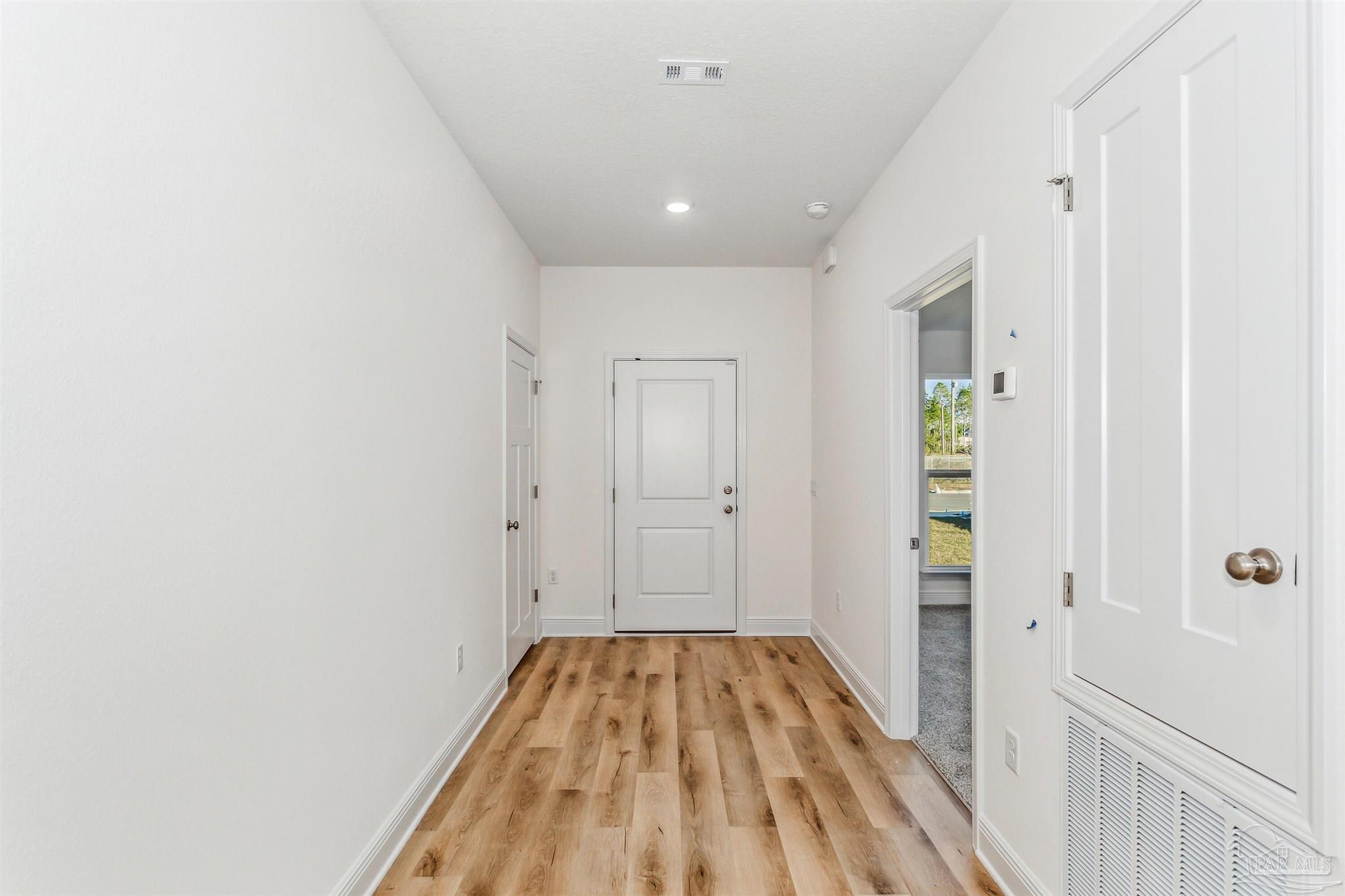 5063 Rainwater Road Milton, FL 32583 - Photo 3 of 22 a view of a hallway with wooden floor and a bathroom